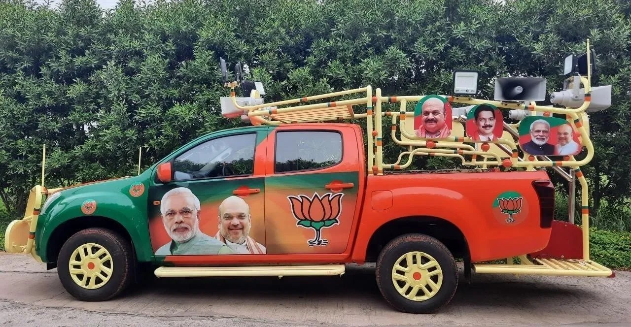 Campaign vehicle wrapped in party branding for a political outreach drive.